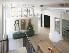 an overhead view of a living room and dining area with wood flooring, white walls and windows