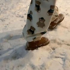 a person standing in the snow wearing brown boots