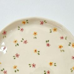 a white plate with yellow and pink flowers on it