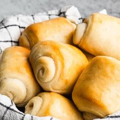 a basket filled with rolls sitting on top of a table