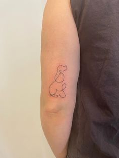 a person with a tattoo on their arm that has a small dog drawn on it