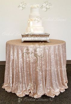 a wedding cake sitting on top of a table next to a silver platter with white flowers