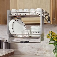 a dish rack with plates and cups on it in the middle of a kitchen counter