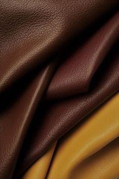 several different colored leathers are stacked together in this close up photo, including brown and yellow