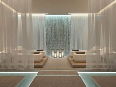 a spa room with white curtains and candles