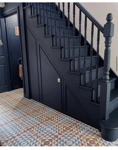 a stair case in the corner of a room next to a door and tiled floor