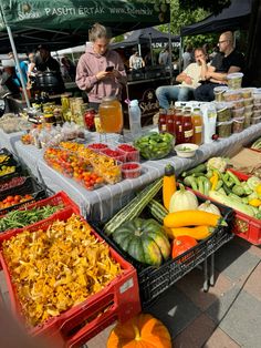 an outdoor market with many different types of fruits and veggies on display for sale