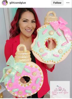 a woman holding two large donuts shaped like doughnuts with bows on them