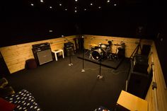 a recording studio is lit up in the dark with lights on and music equipment set up