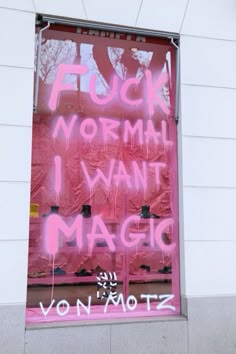 graffiti on the side of a building in front of a pink sign that says i want magic