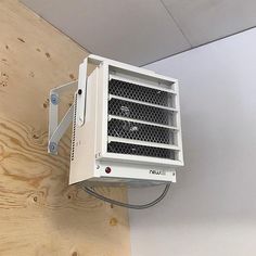 an air conditioner mounted to the side of a wooden wall