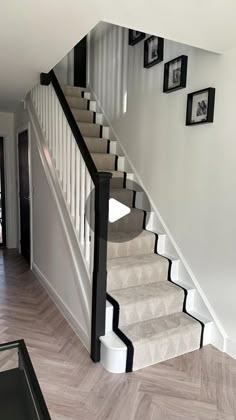 there is a staircase in the house with pictures on the wall and carpeted floor