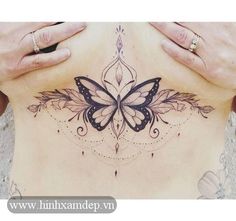 a woman's stomach has a butterfly tattoo on it, and is holding her hands behind her back