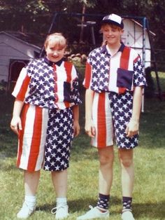 two young boys dressed in patriotic clothing standing next to each other on the grass with trees in the background