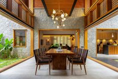 a dining room table and chairs in front of a stone wall with wooden trimmings