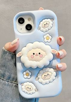 a person holding up a phone case with sheep on it