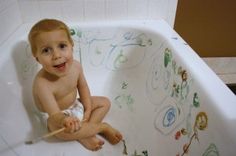 a young child sitting in a bathtub holding a toothbrush