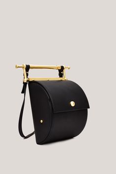 This is Thana. Handmade in Italy, using only the highest quality materials, Thana’s unique shape and gold-coated hardware make it an absolute stand-out. The brand’s signature decorative handle is undoubtedly unique, serving as both an intentional design detail and functional element to the bag. With an adjustable, removable strap the Thana can be styled cross-body, over the shoulder or as a chic handbag. Featuring our signature large interior compartment with pearl detail. Yellow Gold Bag With Gold-tone Hardware And Top Handle, Yellow Gold Bags With Top Handle And Gold-tone Hardware, Yellow Gold Bags With Gold-tone Hardware And Top Handle, Luxury Gold Top Handle Bucket Bag, Modern Gold Shoulder Bag With Metal Hardware, Modern Yellow Gold Bag With Gold-tone Hardware, Designer Gold Bucket Bag With Detachable Handle, Timeless Gold Shoulder Bag With Gold-tone Hardware, Gold Bucket Bag With Top Handle And Gold-tone Hardware