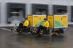 two people in yellow jackets are riding on small motorized bikes with side carts attached to them