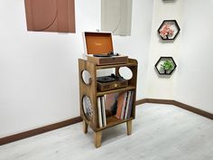 a record player sitting on top of a wooden shelf in front of three hexagonal wall hangings