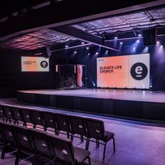 the stage is set up for an event with lights on it and chairs in front