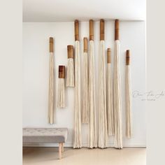 the wall is made out of bamboo sticks and hanging from it's sides, with a bench in front