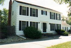 a white two story house with black shutters