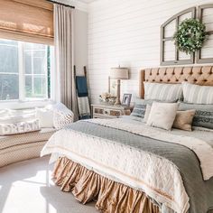 a large bed in a bedroom next to a window