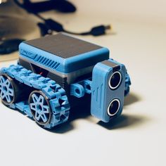 a blue toy truck sitting on top of a white table next to a computer mouse