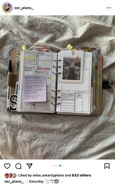 an open planner book sitting on top of a bed