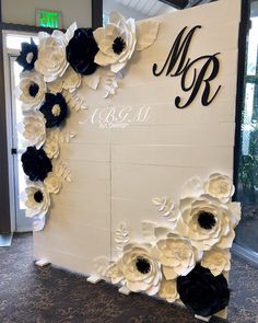 a sign with paper flowers on it that says mr and mrs in black, white and grey