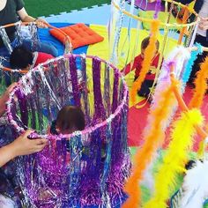 two children are playing with tinsel and streamers in an indoor play area at the park