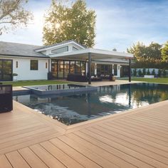 a house with a pool in the middle of it's yard and decking