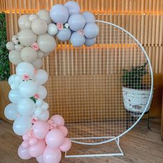 a bunch of balloons that are in front of a wire fence with flowers on it