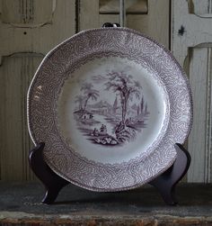 an antique plate is sitting on a stand