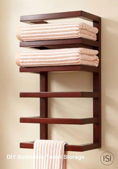 a towel rack with three towels hanging on it's sides and two folded ones in the middle