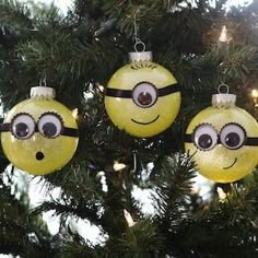 three yellow christmas ornaments with eyes hanging from a tree