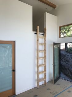 an empty room with a ladder leaning up against the wall