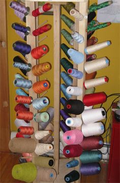 several spools of thread are arranged in a rack