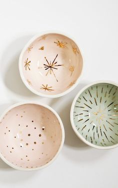 three small bowls with designs on them sitting next to each other in the shape of sunbursts