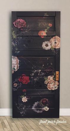 a black cabinet with flowers painted on the front and sides, sitting against a wall