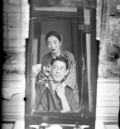 an old black and white photo of two women in front of a television with a camera