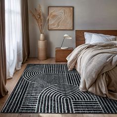 a bed sitting next to a window on top of a wooden floor in a bedroom