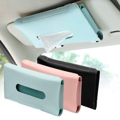 three different colored wallets hanging from the back of a car