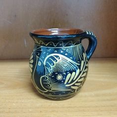 a blue and white vase sitting on top of a wooden table