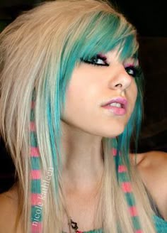 a woman with blue and green hair is posing for the camera