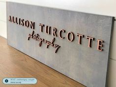 a metal sign that says,'allison turcotte photography'on the side of a wall