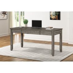 a desk with a laptop on top of it in front of a white rug and wooden floors