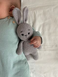 a baby sleeping next to a stuffed animal