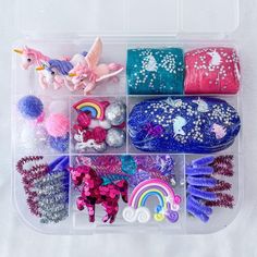 a plastic container filled with lots of different types of hair clips and pony pom poms